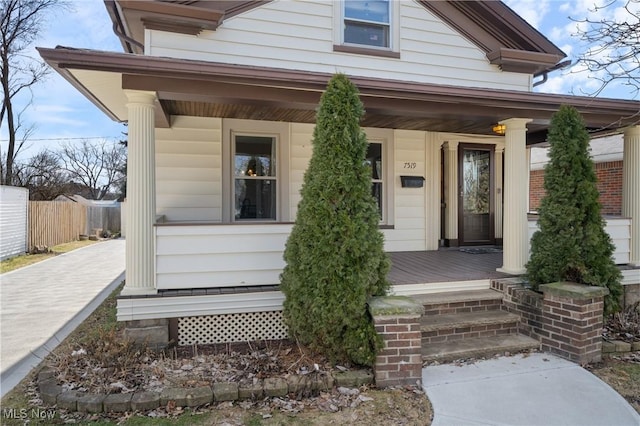 view of front of property with a porch and fence