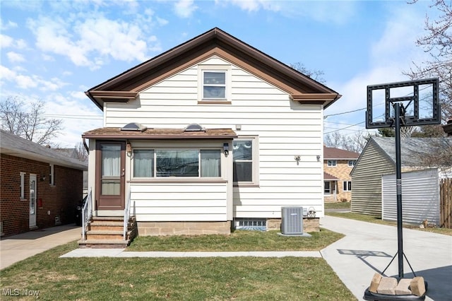 view of front facade featuring entry steps, central AC, and a front yard