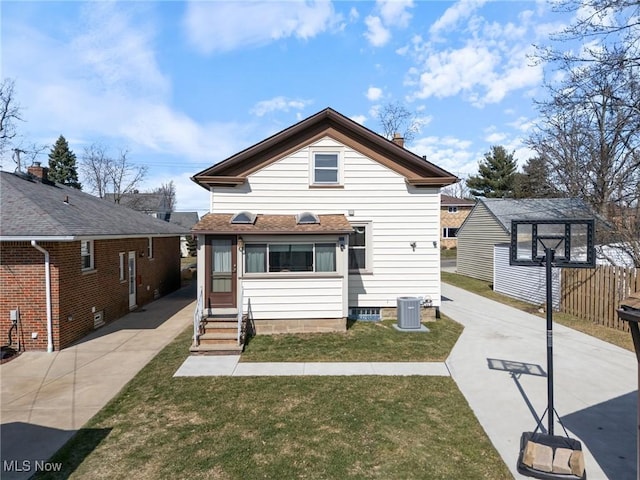 view of front of house featuring a front yard, entry steps, fence, and central air condition unit