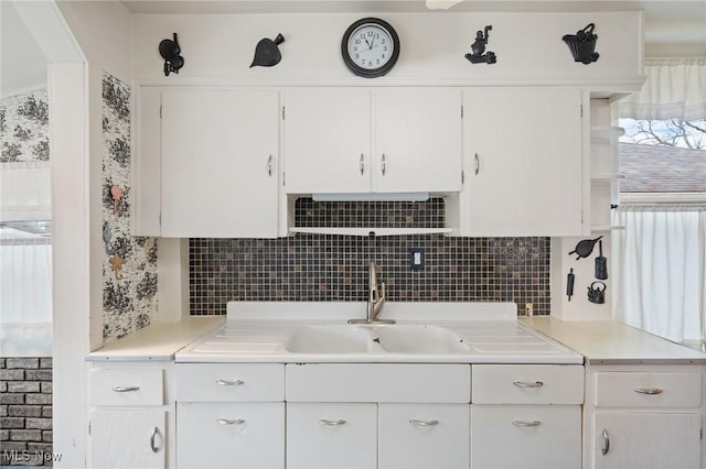 kitchen with white cabinets, decorative backsplash, and light countertops