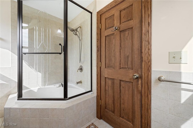 bathroom featuring tiled shower / bath and tile walls