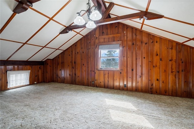 additional living space with lofted ceiling, carpet flooring, and wooden walls