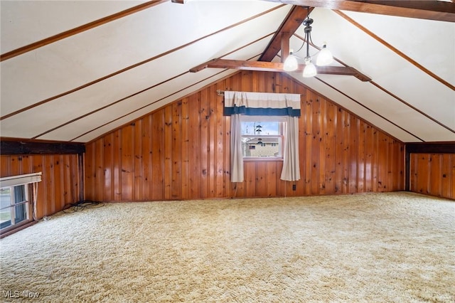 additional living space featuring carpet flooring, wood walls, and lofted ceiling with beams