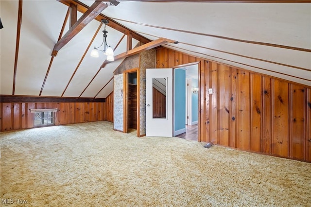 additional living space featuring lofted ceiling with beams, carpet flooring, and wooden walls