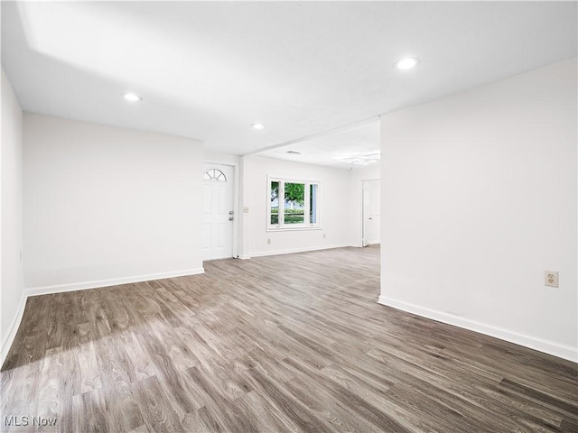 spare room featuring recessed lighting, baseboards, and wood finished floors