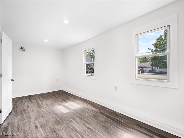 unfurnished room with baseboards, wood finished floors, and recessed lighting