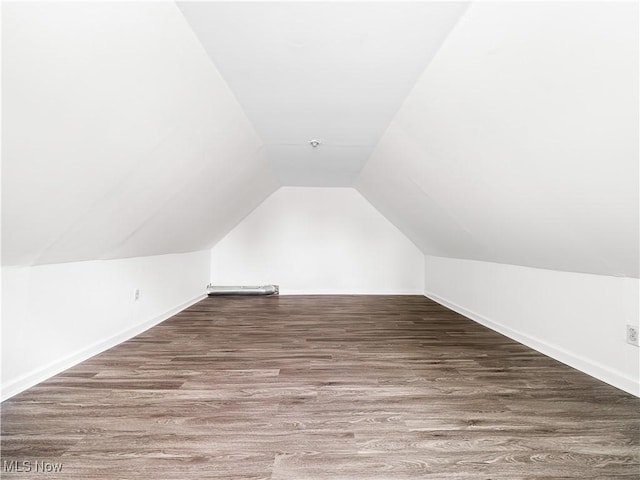 bonus room with lofted ceiling, baseboards, and wood finished floors