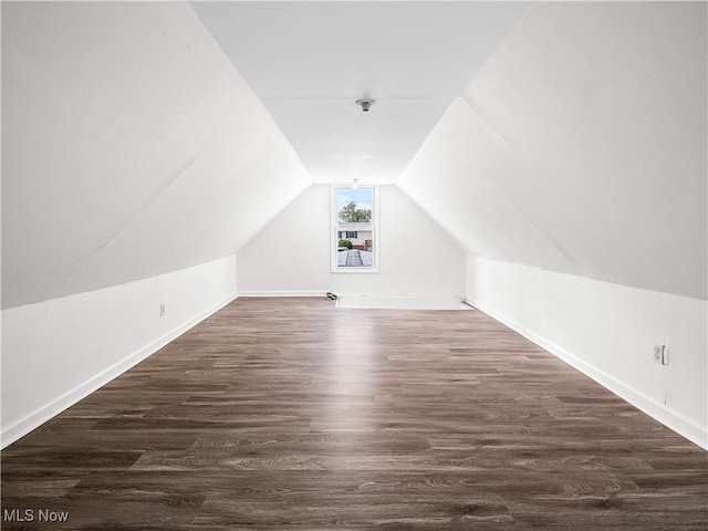 additional living space with baseboards, vaulted ceiling, and wood finished floors