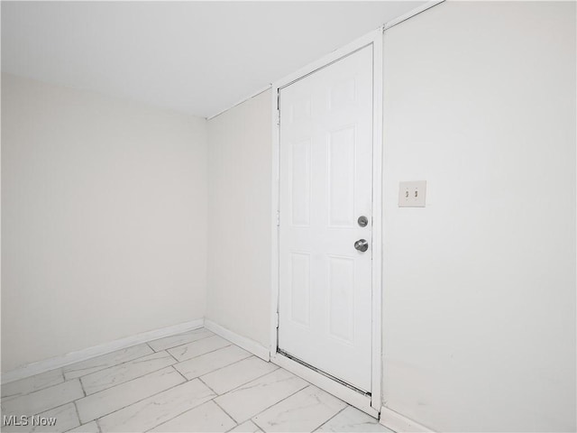 interior space featuring marble finish floor and baseboards