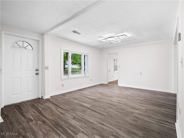 entrance foyer featuring dark wood-style flooring, visible vents, a textured ceiling, and baseboards