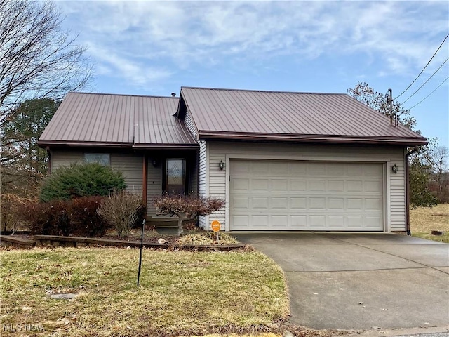 view of front of home featuring metal roof, driveway, and an attached garage