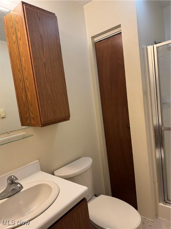 full bathroom with toilet, a shower stall, and vanity