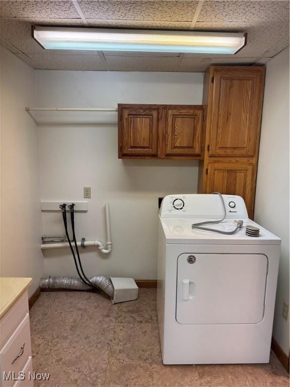 clothes washing area with cabinet space, baseboards, and washer / clothes dryer