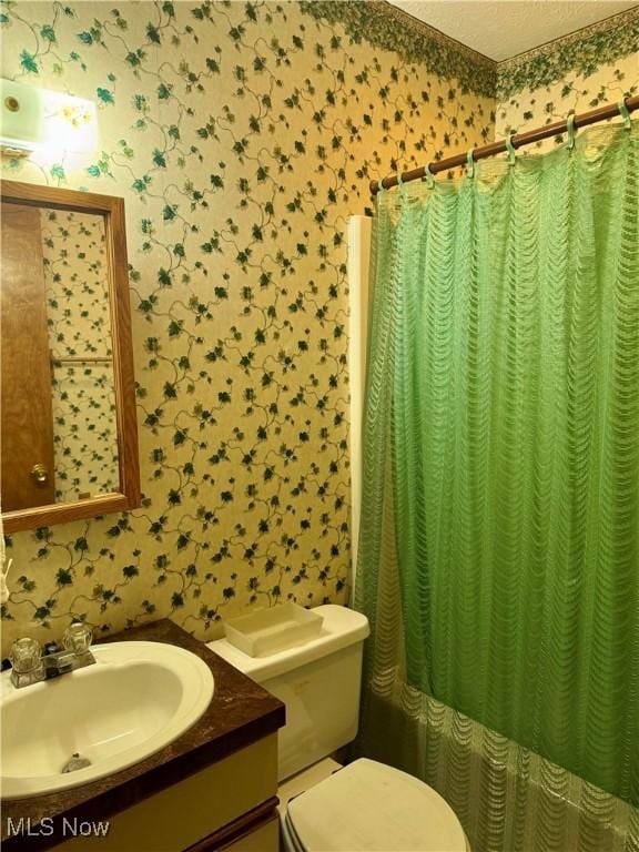 bathroom with a shower with curtain, toilet, and wallpapered walls