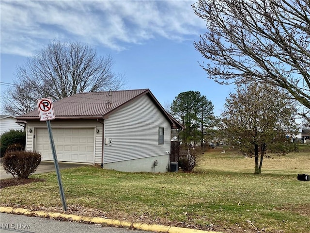 view of property exterior featuring a garage, a yard, metal roof, and driveway