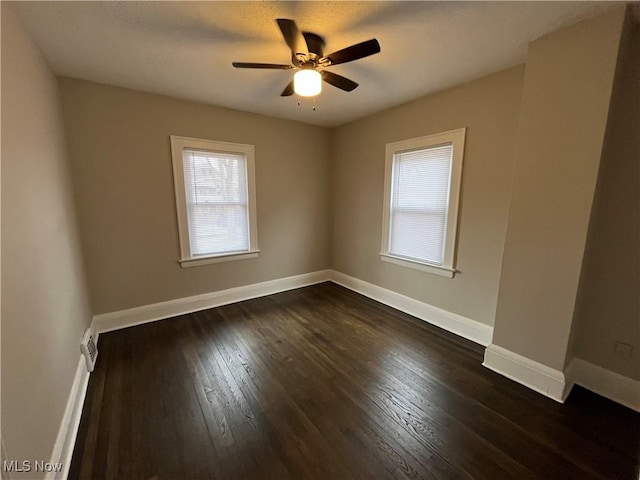 unfurnished room featuring ceiling fan, baseboards, and dark wood-type flooring