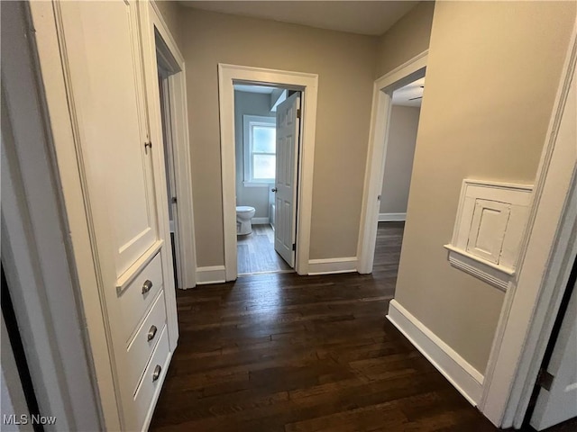 hall with dark wood-style floors and baseboards