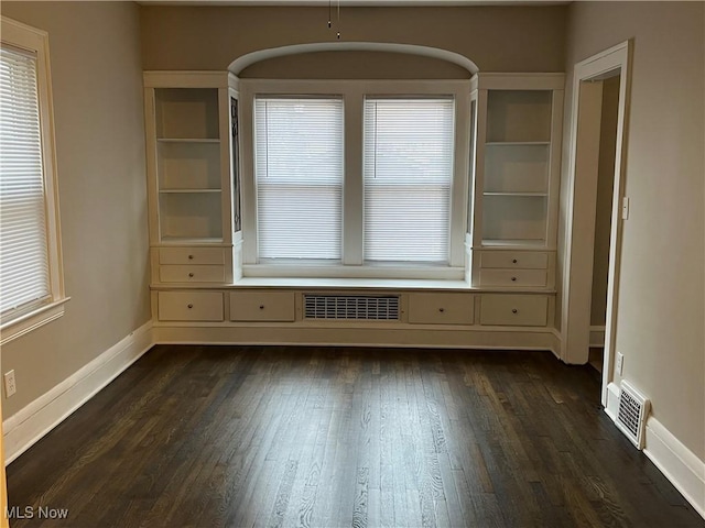 interior space featuring dark wood finished floors, visible vents, and baseboards