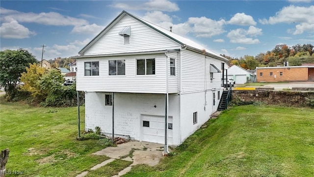 rear view of house featuring a garage and a yard