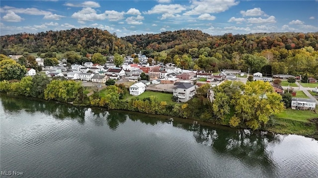 birds eye view of property featuring a water view and a view of trees