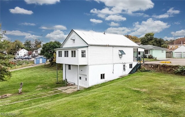 rear view of house featuring a yard