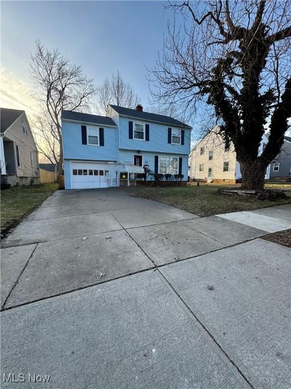 view of front of property featuring a garage, concrete driveway, and a chimney