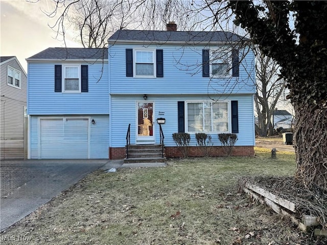 view of front facade featuring aphalt driveway, a chimney, entry steps, a front yard, and a garage