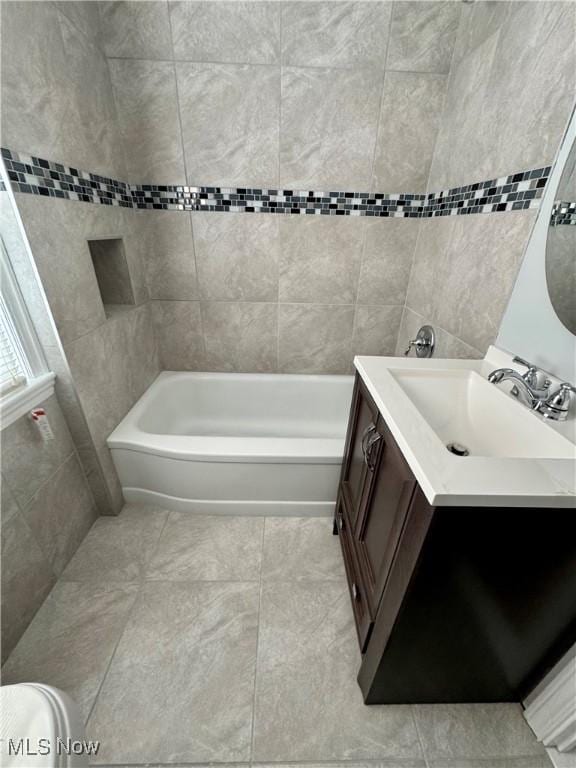 bathroom featuring tile patterned floors, washtub / shower combination, and vanity