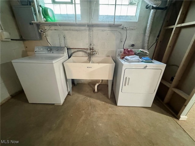 washroom featuring a sink, laundry area, washing machine and dryer, and electric panel