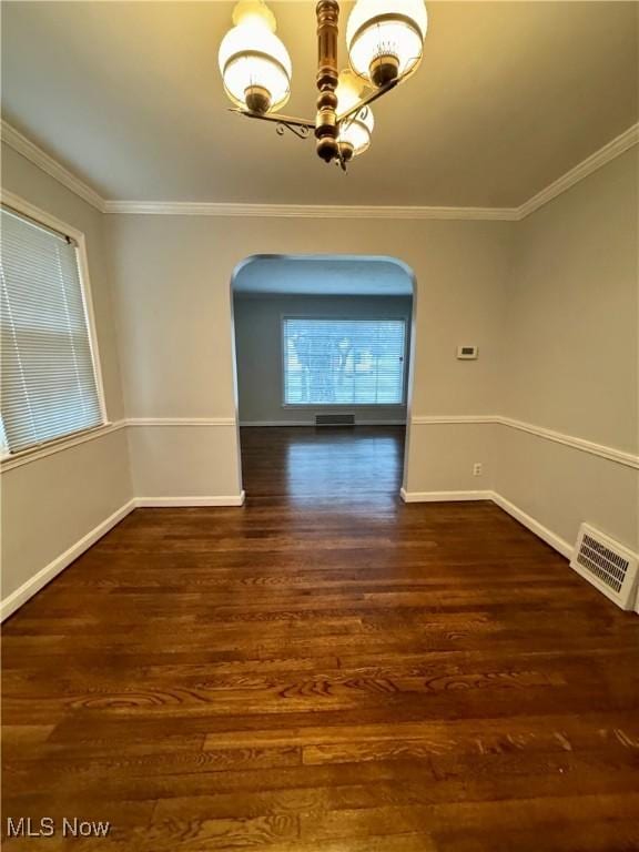 unfurnished dining area with arched walkways, visible vents, and wood finished floors