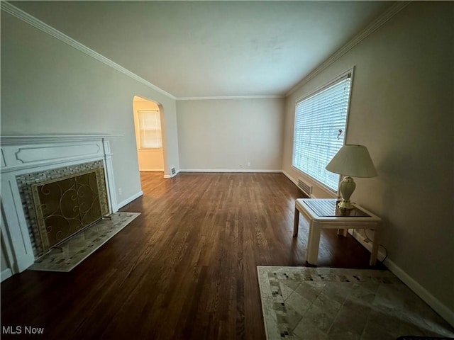 unfurnished living room featuring arched walkways, a premium fireplace, wood finished floors, visible vents, and baseboards