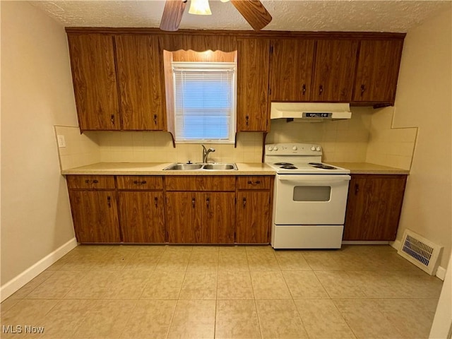 kitchen featuring electric range, visible vents, brown cabinets, under cabinet range hood, and a sink