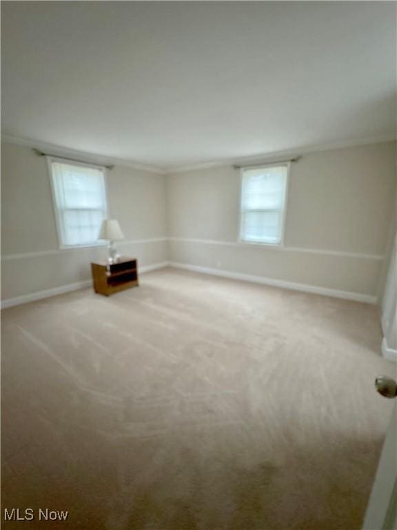 spare room featuring carpet and baseboards