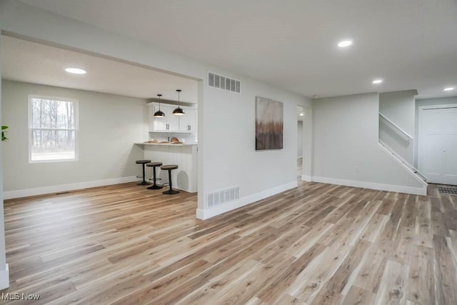 interior space with light wood-style flooring, visible vents, and baseboards