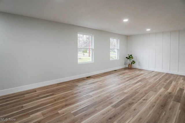 unfurnished room featuring recessed lighting, wood finished floors, and baseboards