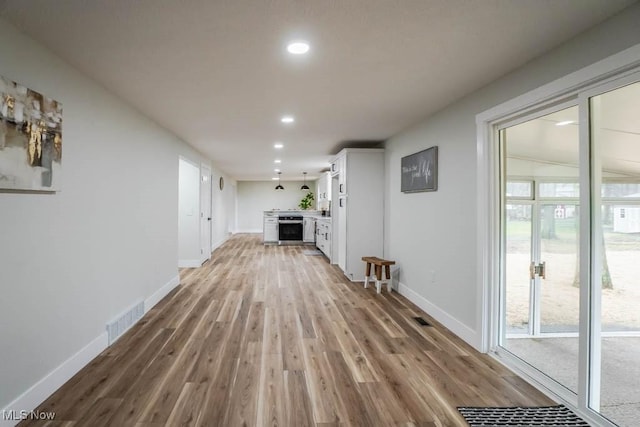 unfurnished living room featuring recessed lighting, baseboards, visible vents, and light wood finished floors