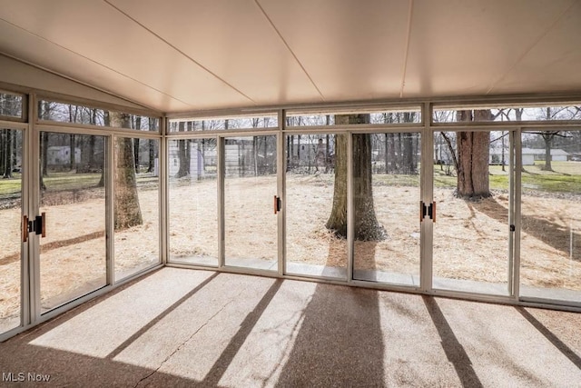 unfurnished sunroom featuring lofted ceiling and a healthy amount of sunlight