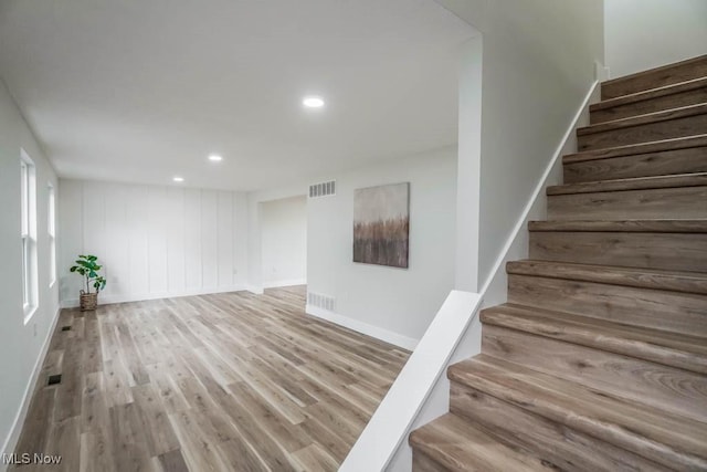 interior space featuring baseboards, visible vents, wood finished floors, and recessed lighting