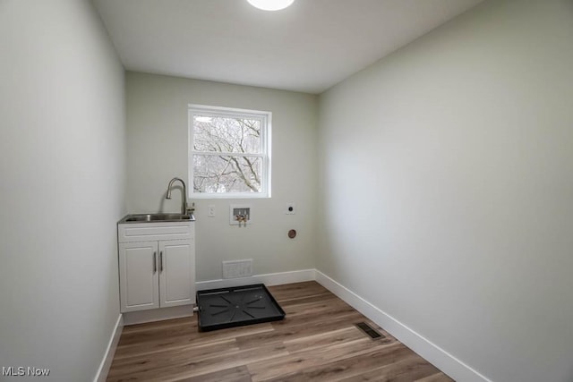 laundry area featuring a sink, cabinet space, visible vents, and hookup for an electric dryer