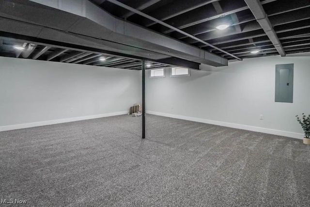 basement with carpet, electric panel, and baseboards