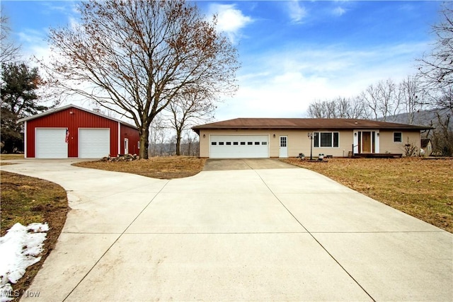 ranch-style house featuring a front yard and a detached garage