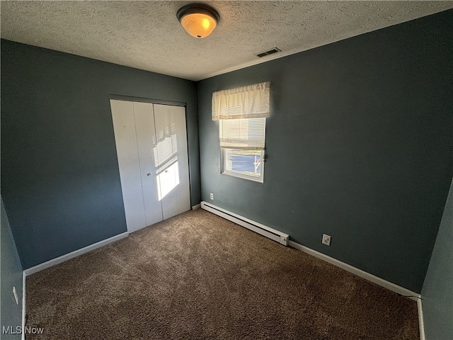 unfurnished bedroom featuring a baseboard radiator, a closet, visible vents, carpet flooring, and baseboards