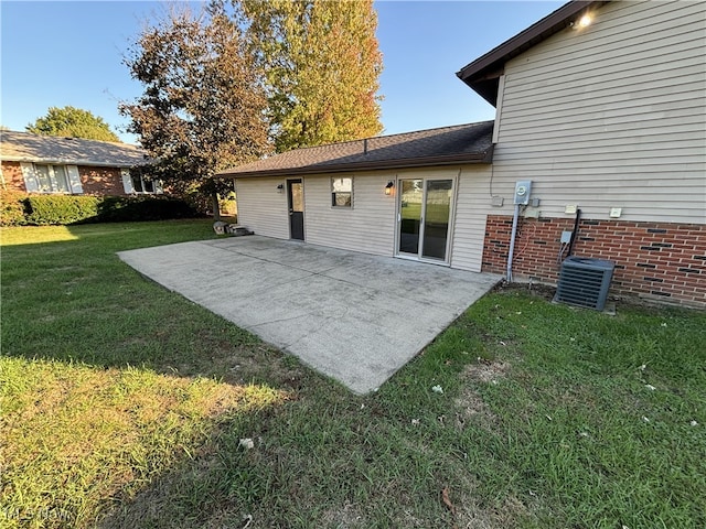 back of house featuring central air condition unit, a lawn, and a patio