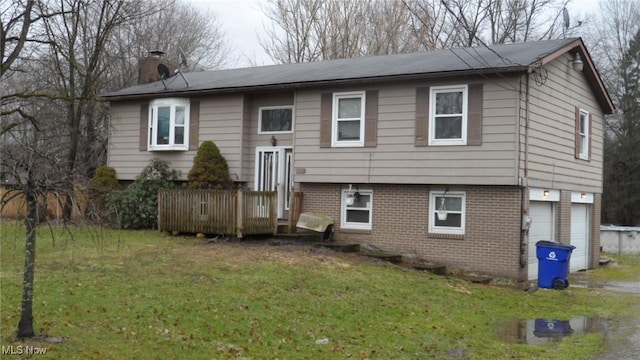 view of front of home featuring brick siding, a chimney, a front yard, and a wooden deck