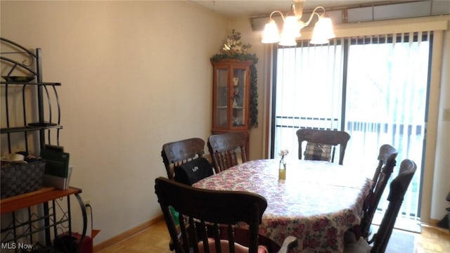 dining space featuring baseboards and an inviting chandelier