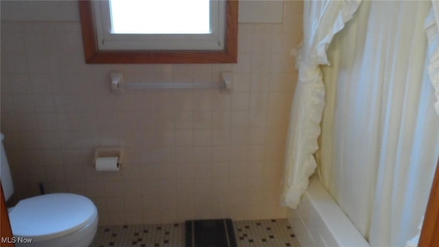 full bathroom with toilet, tile walls, and tile patterned floors
