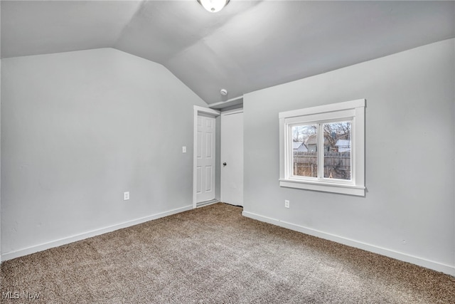 empty room with lofted ceiling, baseboards, and carpet floors