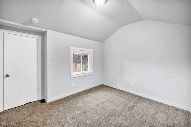 bonus room featuring lofted ceiling, carpet floors, and baseboards