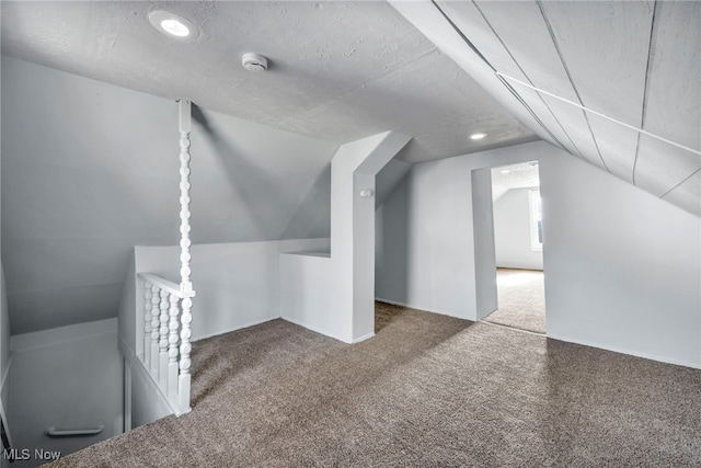 additional living space featuring carpet floors and vaulted ceiling