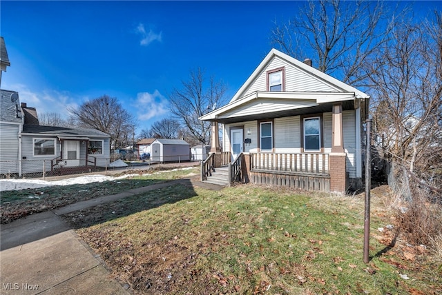 bungalow-style house featuring covered porch and a front lawn